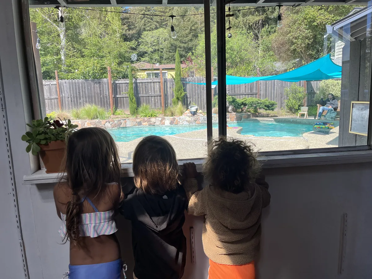 Children watching a swim lesson through the changing room window at Little Fish Swim School Felton