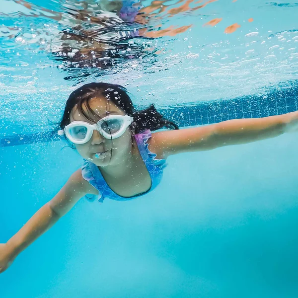Young swimmer underwater with goggles, learning to swim at Little Fish Swim School